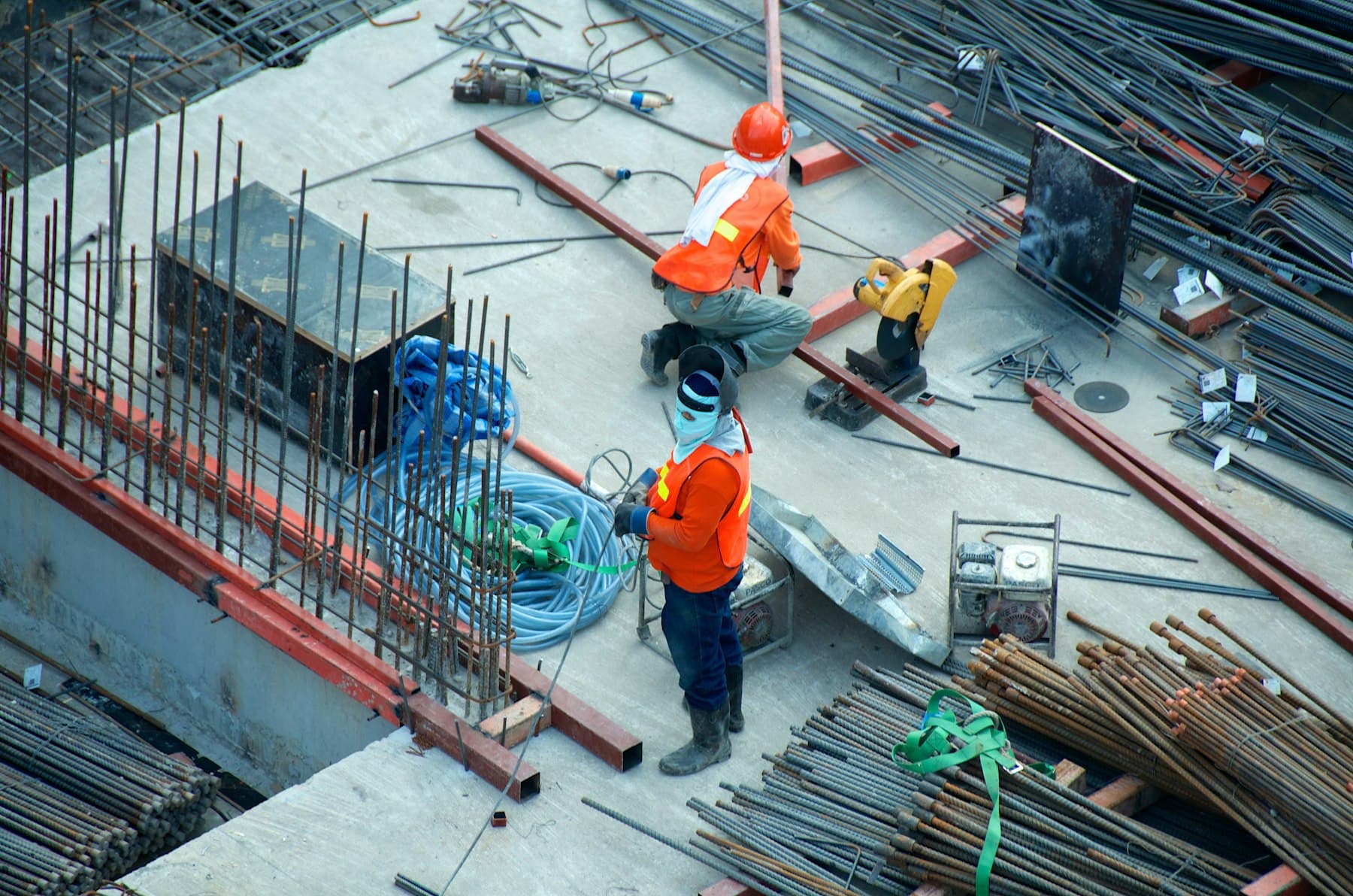 Construction workers preparing reinforcement steel on a concrete slab